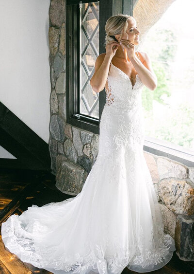 Bride in wedding dress smiling by the window