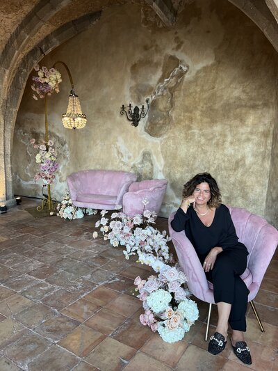 Positano wedding planner Emma sitting on pink chair