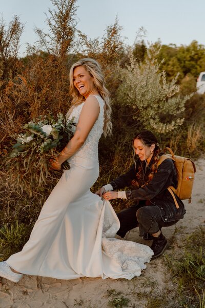 photographer helping bride with her dress