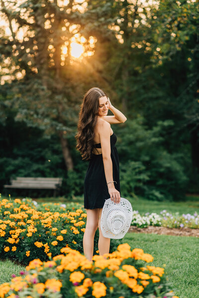 Woman in white dress smiling at the camera on path to beach