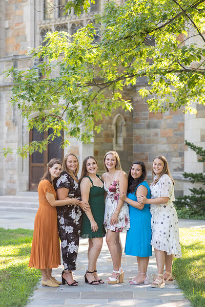 Group of girls smiling on campus celebrating graduation