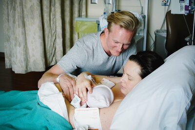 Mother and father gaze over their newborn after a hospital birth in Norman, OK.