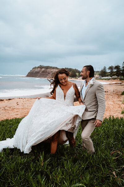 Couple in wedding attire on the beach.