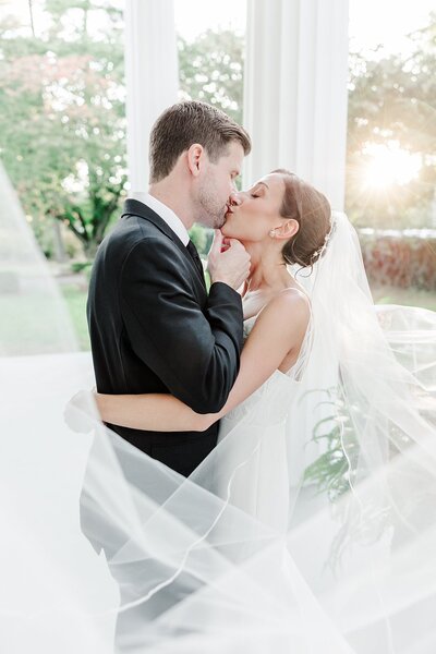 bride and groom holding hands as wedding party smiles in the background