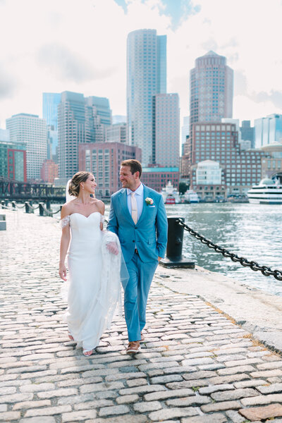 bride and groom walking with trees in the background