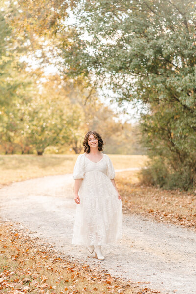 Senior walks on path at Greenway Farms during senior portrait session with Chattanooga photographer