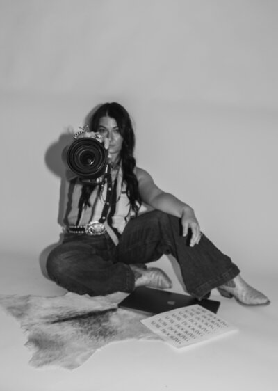 Black and white posed photo of Southwestern Missouri photographer with her camera