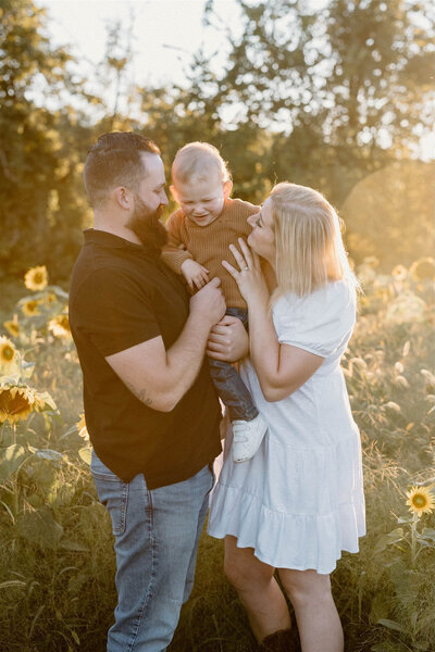 Golden hour family photography session in Ottawa sunflower field by lifestyle portrait photographer Stacy Kenopic.