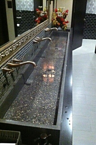Concrete vessel trough sink with three wash stations in terrazzo on a carbon concrete countertop meeting ADA requirements