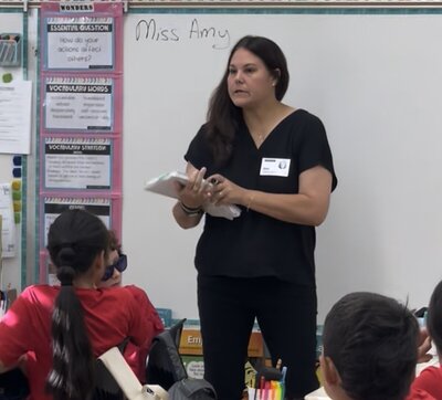 literacy consultant coaching at the front of a classroom