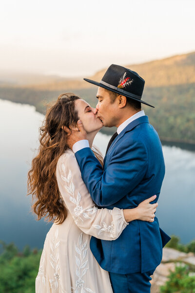 Couple with their dog kissing after their vows. Captured by their New England Elopement Photographer