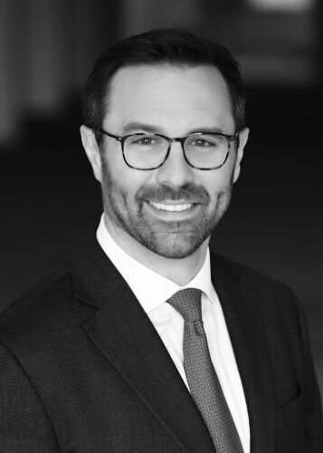 A black and white headshot of the Founder and CEO of Harper Fig, John Celani