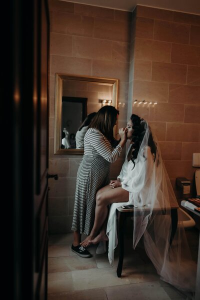 Makeup artist applying makeup to a bride, representing one of many vendors at the Crush Collective wedding expo.