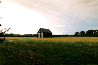 House with wall of windows in field