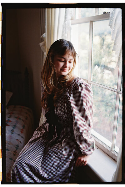 A candid portrait of Ember Claire, the lead photographer, exuding warmth and approachability, reflecting her passion for storytelling through non-intrusive observation.