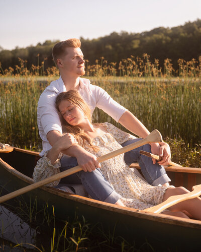 A couple canoeing across the lake during their engagement session near Schuylerville, New York.