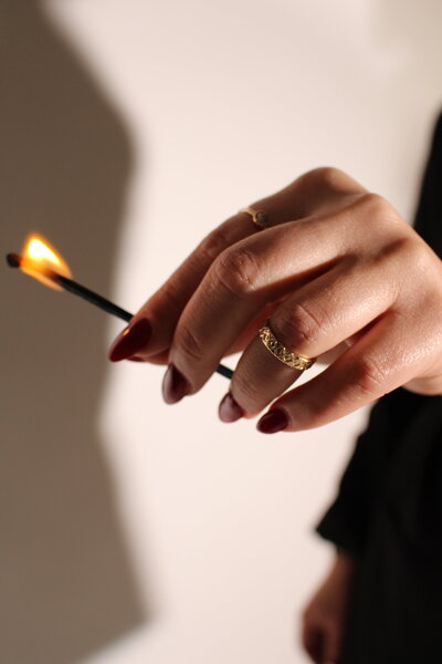 Hand holding a lit match