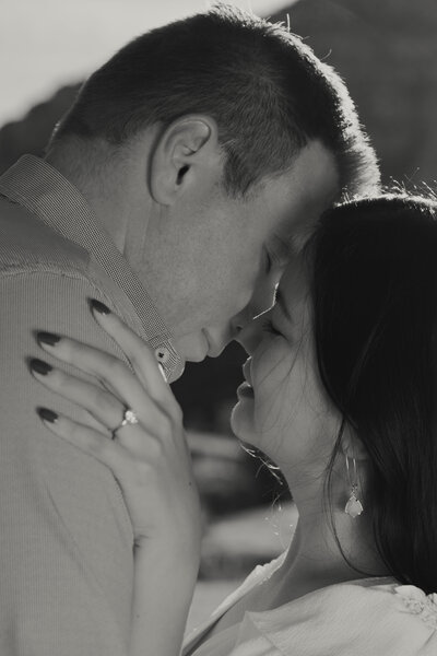 Engaged couple kissing at sunset in Sedona red rocks.
