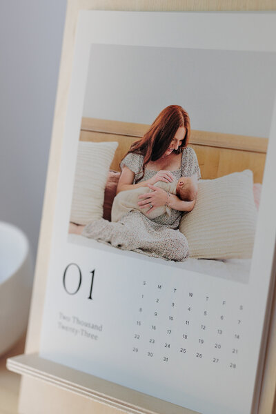 A calendar displaying a photo of a mom holding her newborn baby in bed