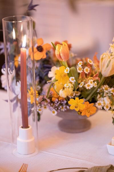 A warm, organic centerpiece with a candle next to it.