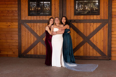 Bride sharing a warm hug with her bridesmaids during a Utah wedding, photographed by Lamblight Photography