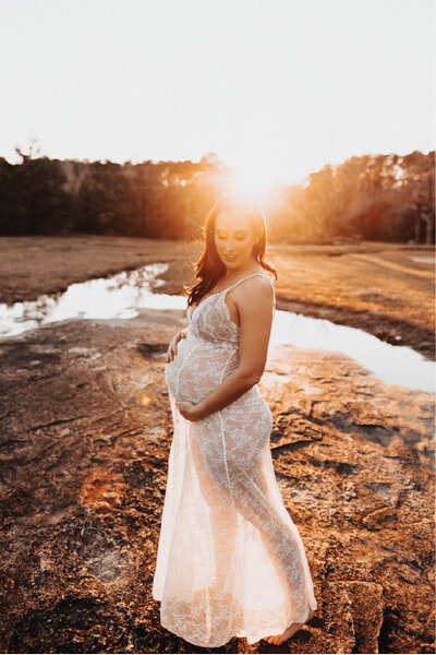 Pregnant woman in white dress in field