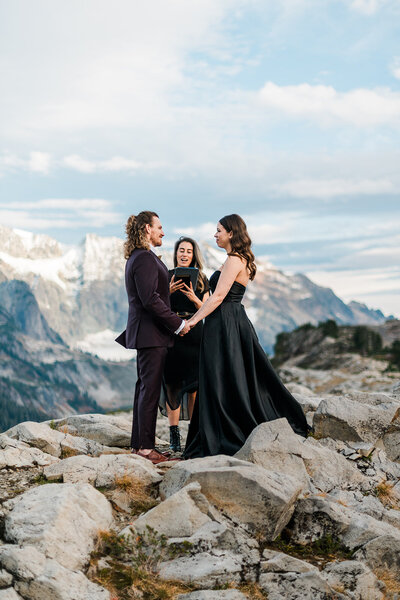 Bride in black dress and groom with their officiant during their Artist Point elopement near Mount Baker!