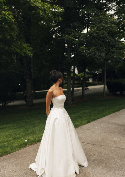  a bride standing on the sidewalk looking away