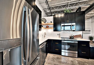 Kitchen with stainless  steel appliances in this one-bedroom, one-bathroom rental condo in the historic Behrens building just blocks from the Magnolia Silos and Baylor University in downtown Waco, TX.
