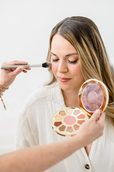 Mom having makeup applied in studio