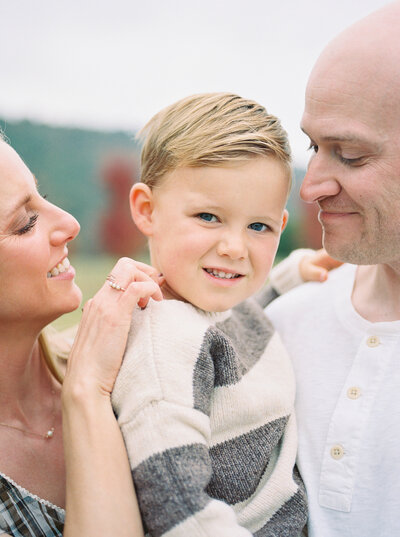 Film image of mother and father gazing lovingly at their 3 year old son in a Little Rock park.