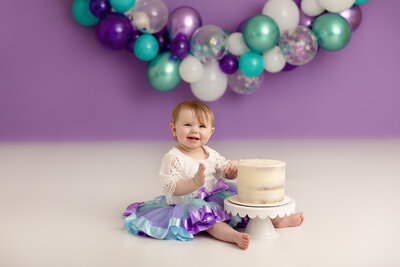 purple and teal themed 1st birthday cake smash with baby girl by milestone photographer new philadelphia