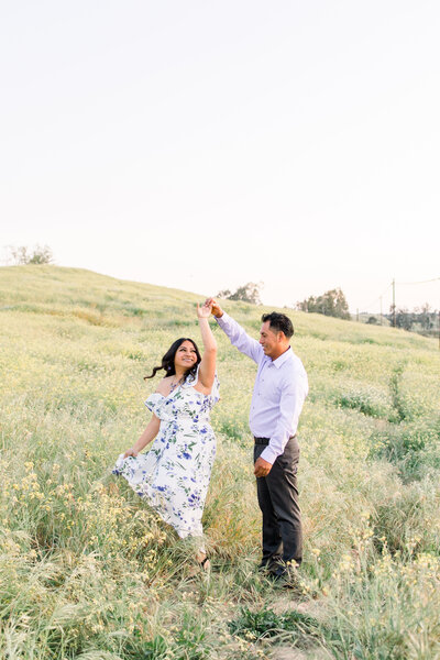 Engaged couple poses together on a flower field in Fresno