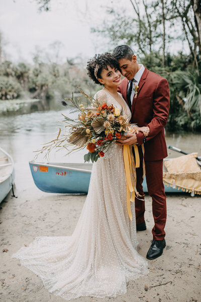 bride and groom in front of boat