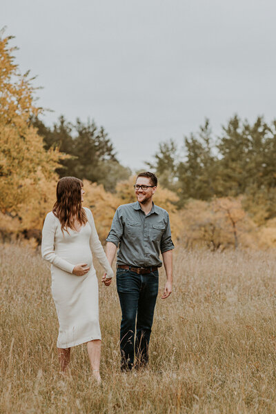 Maternity Lifestyle photo of couple walking in the field