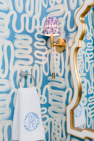 Bold patterned bathroom design with gold mirror