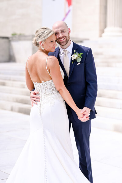 A close up shot of a bride and groom holding hands on the steps of the Cleveland Museum of Art