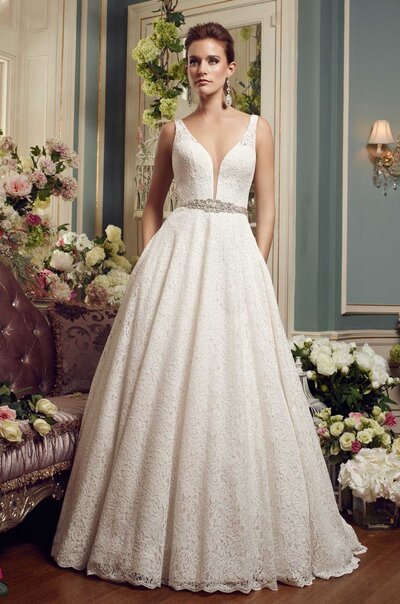 Mikaella Lace Wedding Dress. Mikaella Lace gown with sleeveless bodice and plunging neckline. Removable Mokuba Ribbon with beading at waist. Full circle skirt with pockets and scallop at hem.