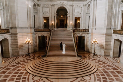 newlyweds walk up grand staircase