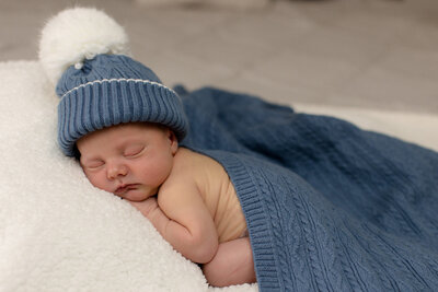 photo of baby boy in blue beanie draped in blue blanket