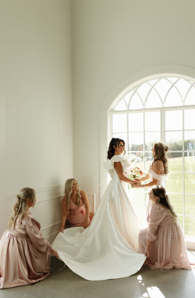 West Wind Hills Bridesmaids fixing brides wedding dress. Pacific Mo Wedding St. Louis Wedding
