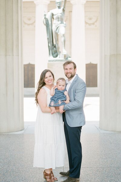 a-mom-and-dad-are-holding-their-one-year-old-at-cheekwood-for-her-1-year-old-portraits-at-cheekwood-with-dolly-delong-photography