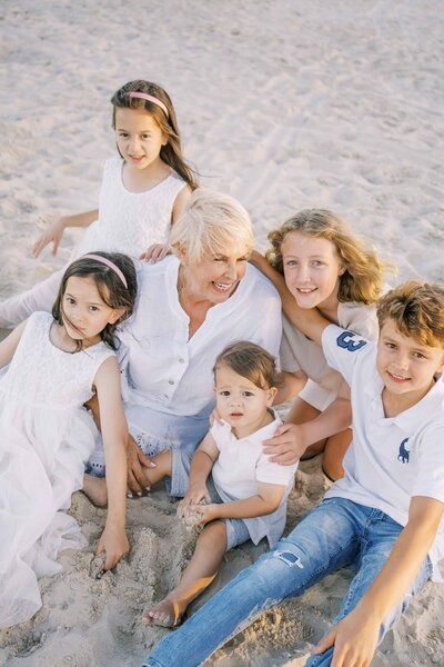 Grandma holding her grandkids close on a Brisbane beach having lifestyle family portraits taken.