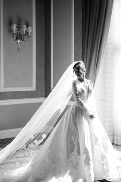 Bride near window wearing veil, taken by Detroit wedding photographer Courtney Rudicel
