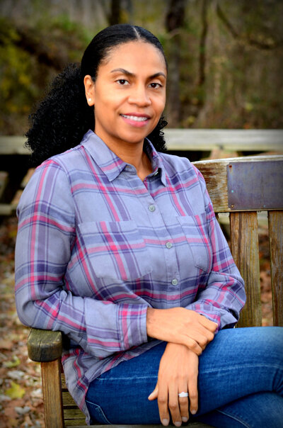 Keauna, sitting on a bench. She is a Compassionate Doula offering a variety of post partum services to support mothers.