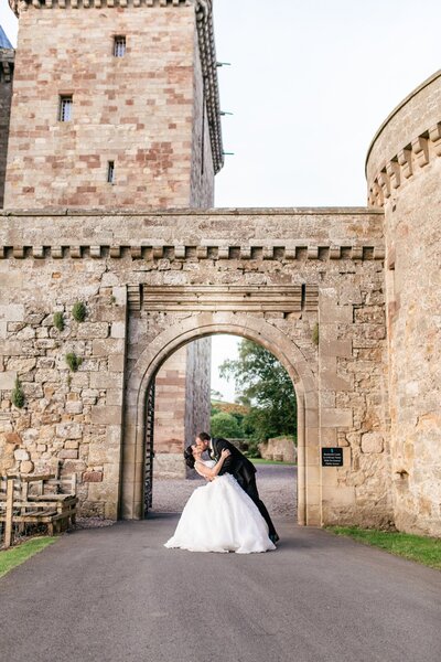 couple kissing in front of castle entrence