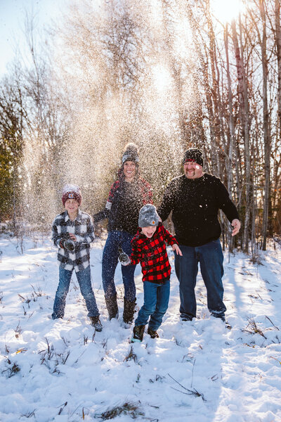 Family of four throwing snow in the sky - Park Rapids, Minnesota