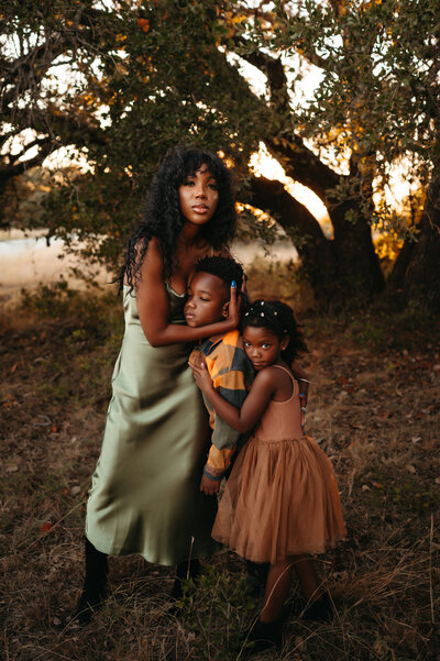 A mother holds her two young children close.
