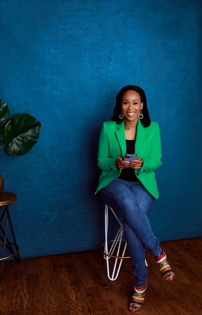 Charmaine Green Forde CEO of Chapter tOO™ smiling at camera holding phone