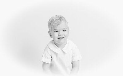 Black-and-white heirloom portrait of a young boy in a collared shirt.